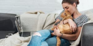 A woman is sitting on a couch with her cat.